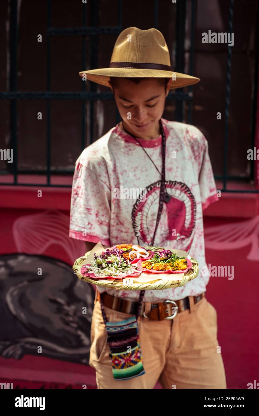 Junger gemischter alternativer Reisender mit rosa Burritto in Mexiko Stockfoto