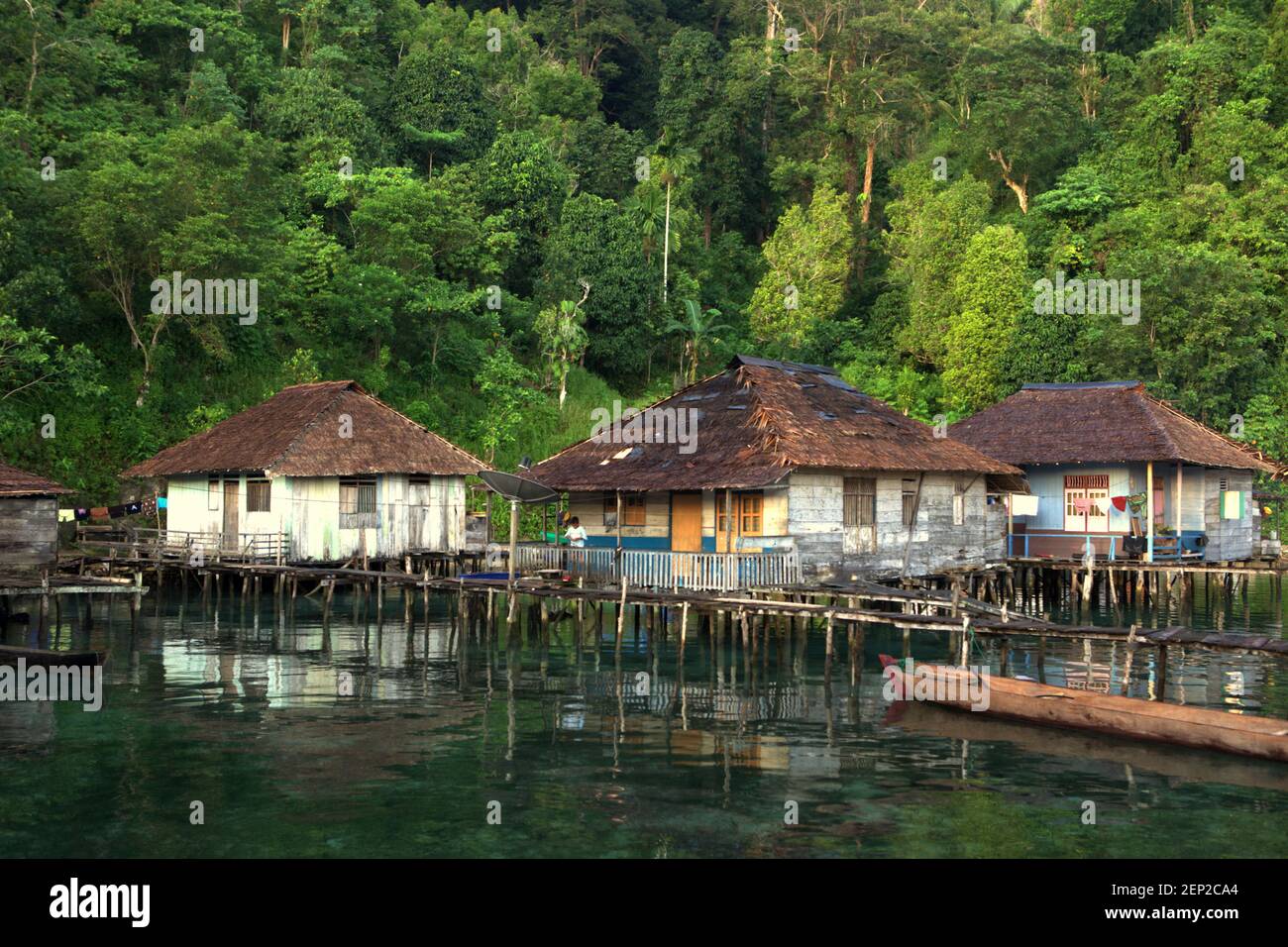 Pfahlbauten, die als Öko-Lodges über dem Küstenwasser in Sawai entworfen wurden, einem Fischerdorf, das sich teilweise verwandelt und Ökotourismus in Nord-Seram, Central Maluku, Maluku, Indonesien anbietet. Stockfoto
