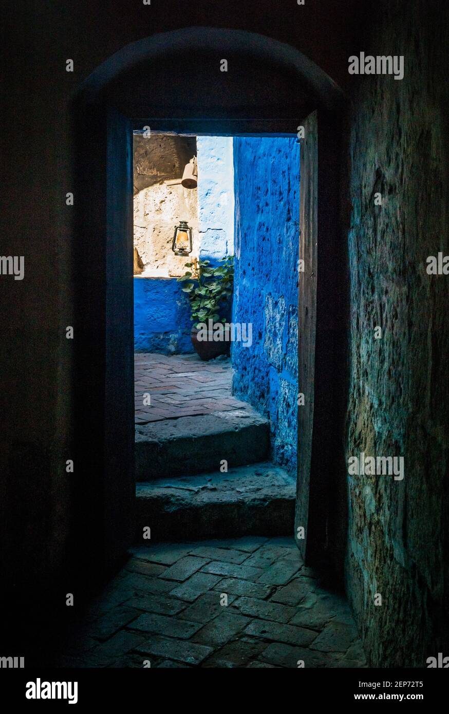 Arequipa, Peru - Juli 20 2010: Eingangstür mit bunten blauen Wänden und einer altmodischen Kerosin- oder Petroleumlampe in Santa Catalina de Siena Mona Stockfoto