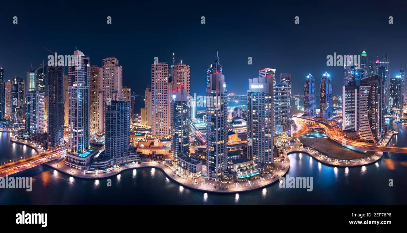 Die Dubai Marina Towers leuchten nachts in einem Panoramablick Mit Atlantis The Palm im Hintergrund Stockfoto