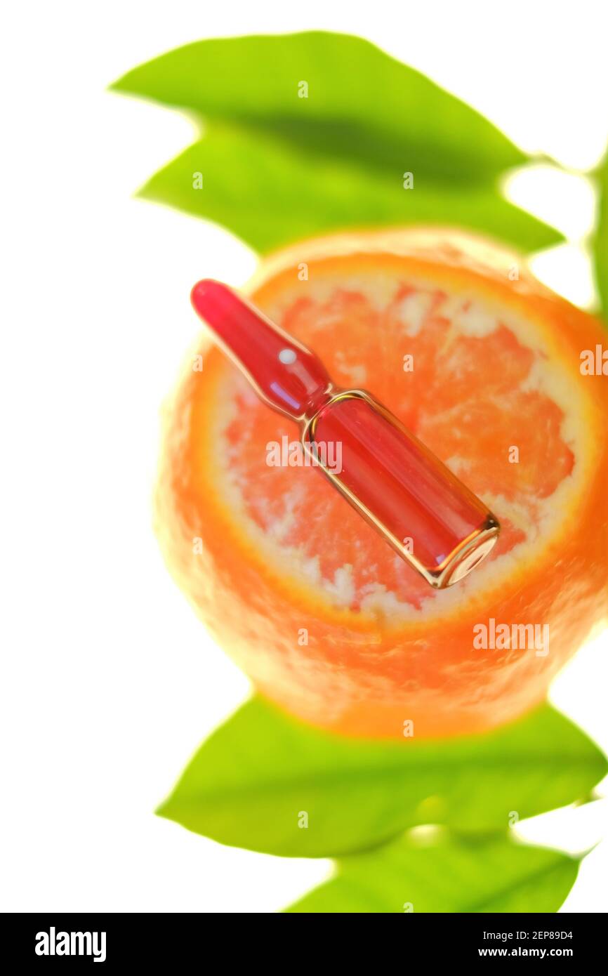 Vitamin C. Serum mit Vitamin C. Glasampulle auf Mandarinen Früchte mit grünen Blättern isoliert auf weißem Hintergrund.Prävention von Immunität gegen Viren Stockfoto