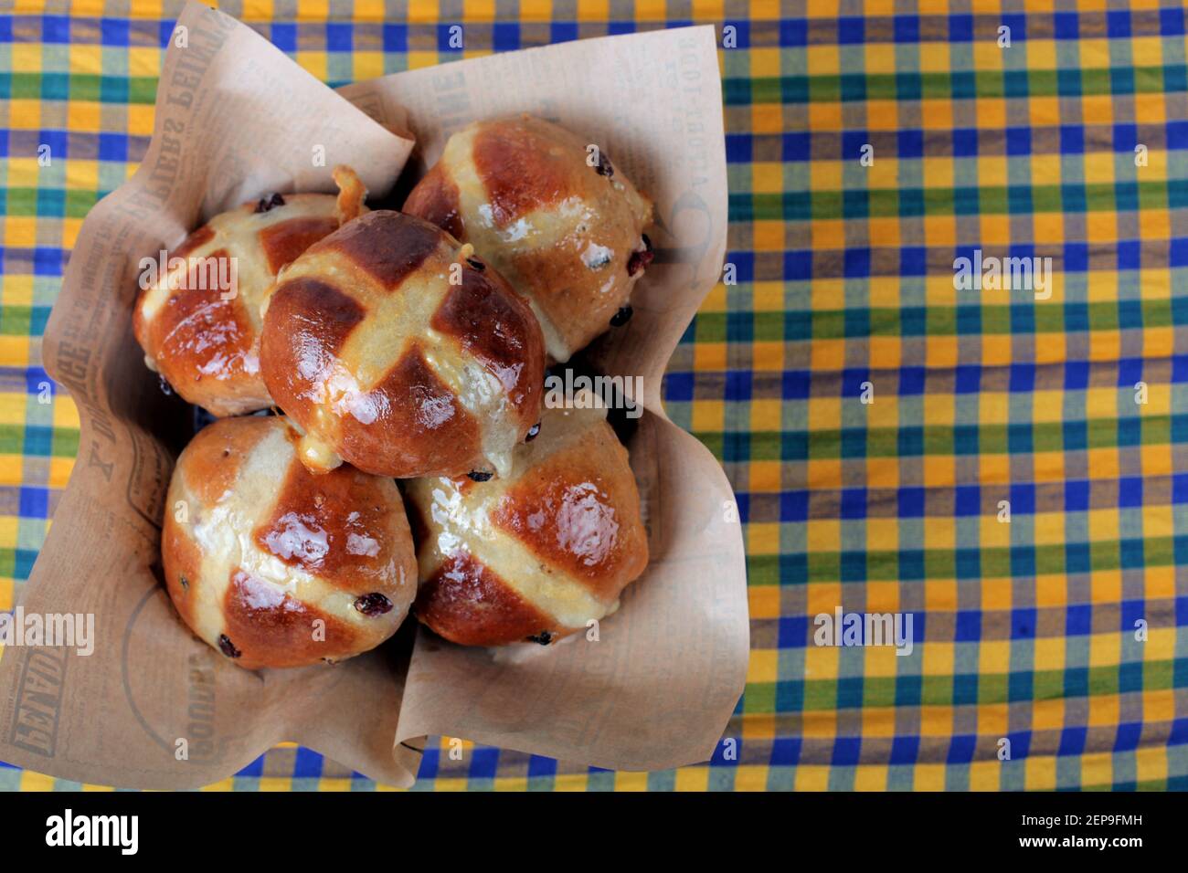 Fünf heiße Kreuzbrötchen in einem Korb zu Ostern. Stockfoto
