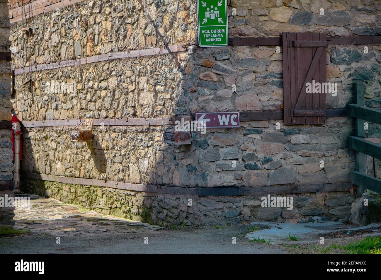 Zeichen von WC und Muster Punkt mit grünen Brett hängen an alten und alten Stil Wand. Übersetzung von Wörtern in grünen Tabella ist "muster Punkt". Stockfoto