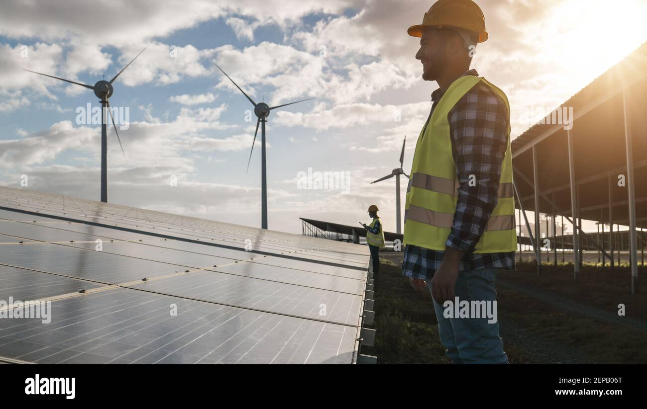 Mann, der für Sonnenkollektoren und Windkraftanlagen arbeitet - Renewable Energy Concept - Fokus auf männliche Arbeitnehmer Gesicht Stockfoto