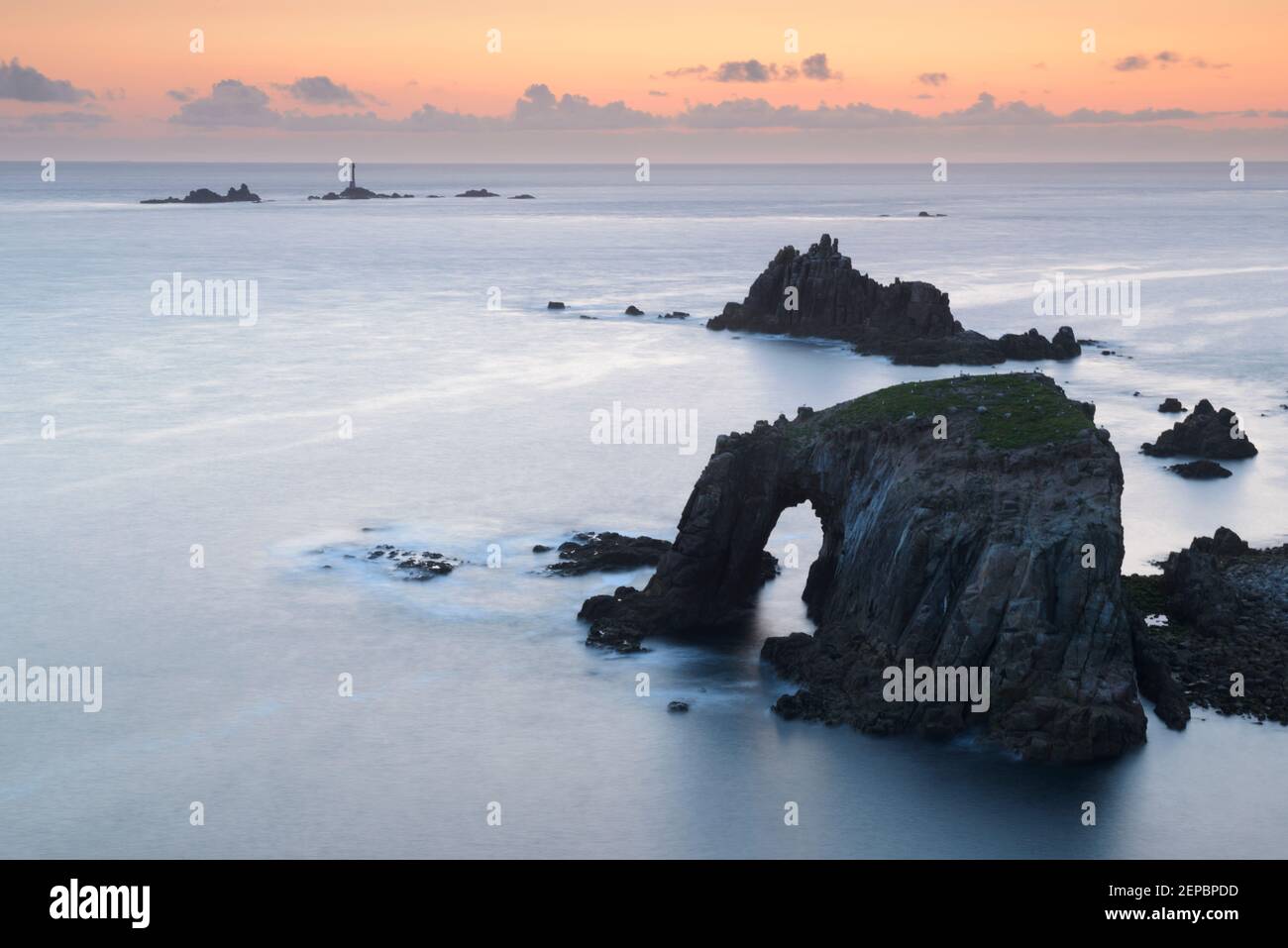 Die Dämmerung fällt über Enys Dodnan, dem Armed Knight und Longships Lighthouse am Land's End, Cornwall Stockfoto