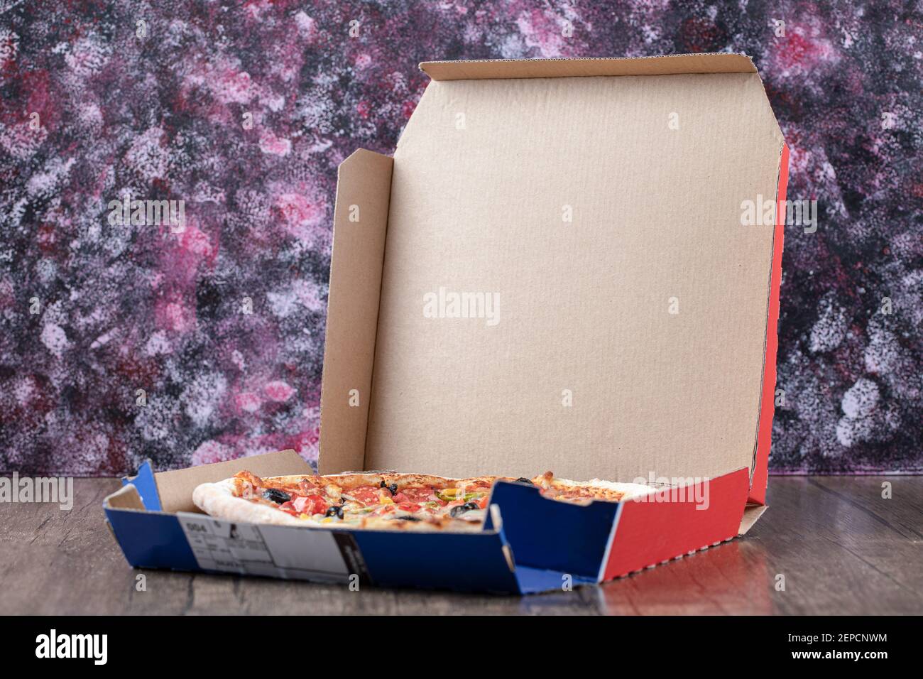 Hot Mixed Pizza in offener Box über Holztisch Stockfoto