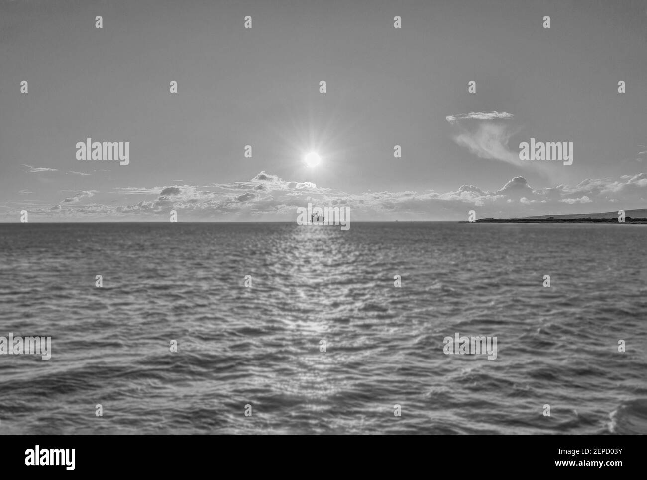 Ein Kunstbild eines Schiffs am Horizont Unter dem Scheinwerferlicht Sonne in schwarz und weiß Stockfoto