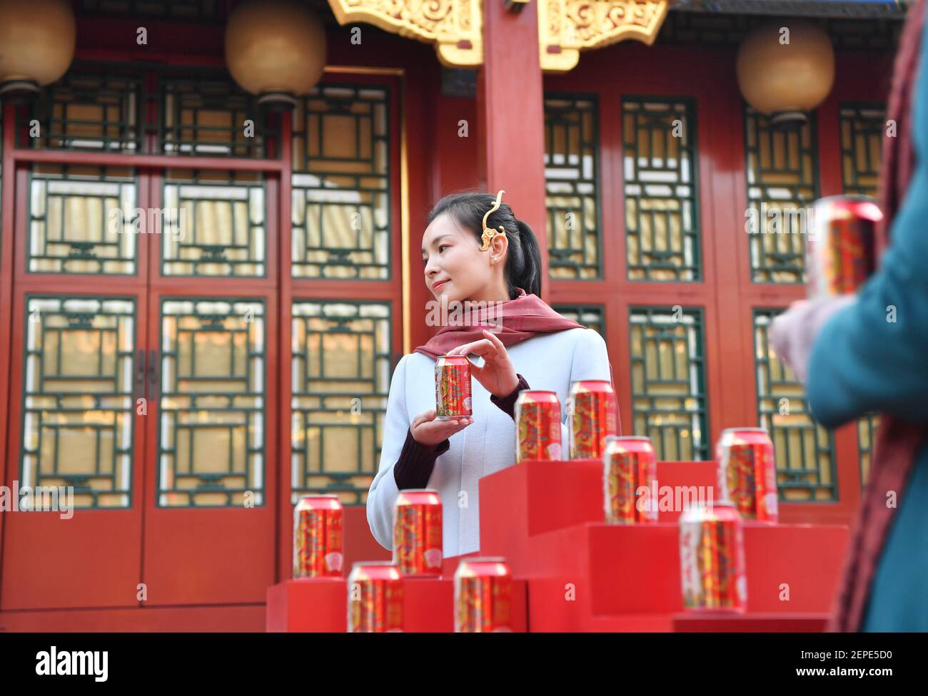 Ein Modell zeigt die kollaborierte Version des Palastmuseums und des chinesischen Erfrischungsgetränkeherstellers Jianlibao, auf der Muster aus Drachenroben des Qianlong Kaisers der Qing Dynastie, Peking, China, 9. Dezember 2019 zu sehen sind. Stockfoto