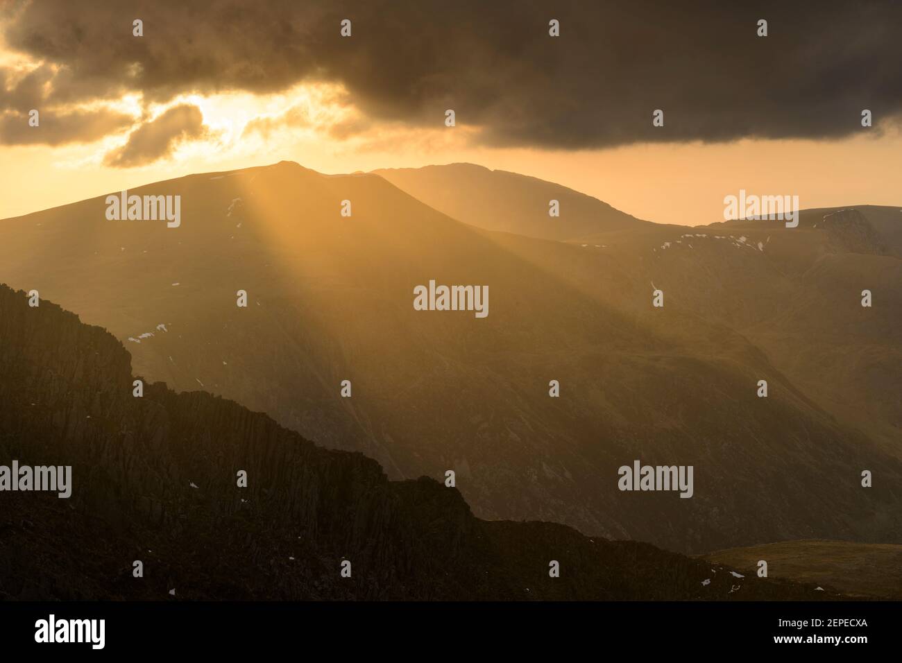 Crepuscular Strahlen beleuchten die Landschaft rund um Y Garn in der Glyderauer Berge, Snowdonia. Stockfoto