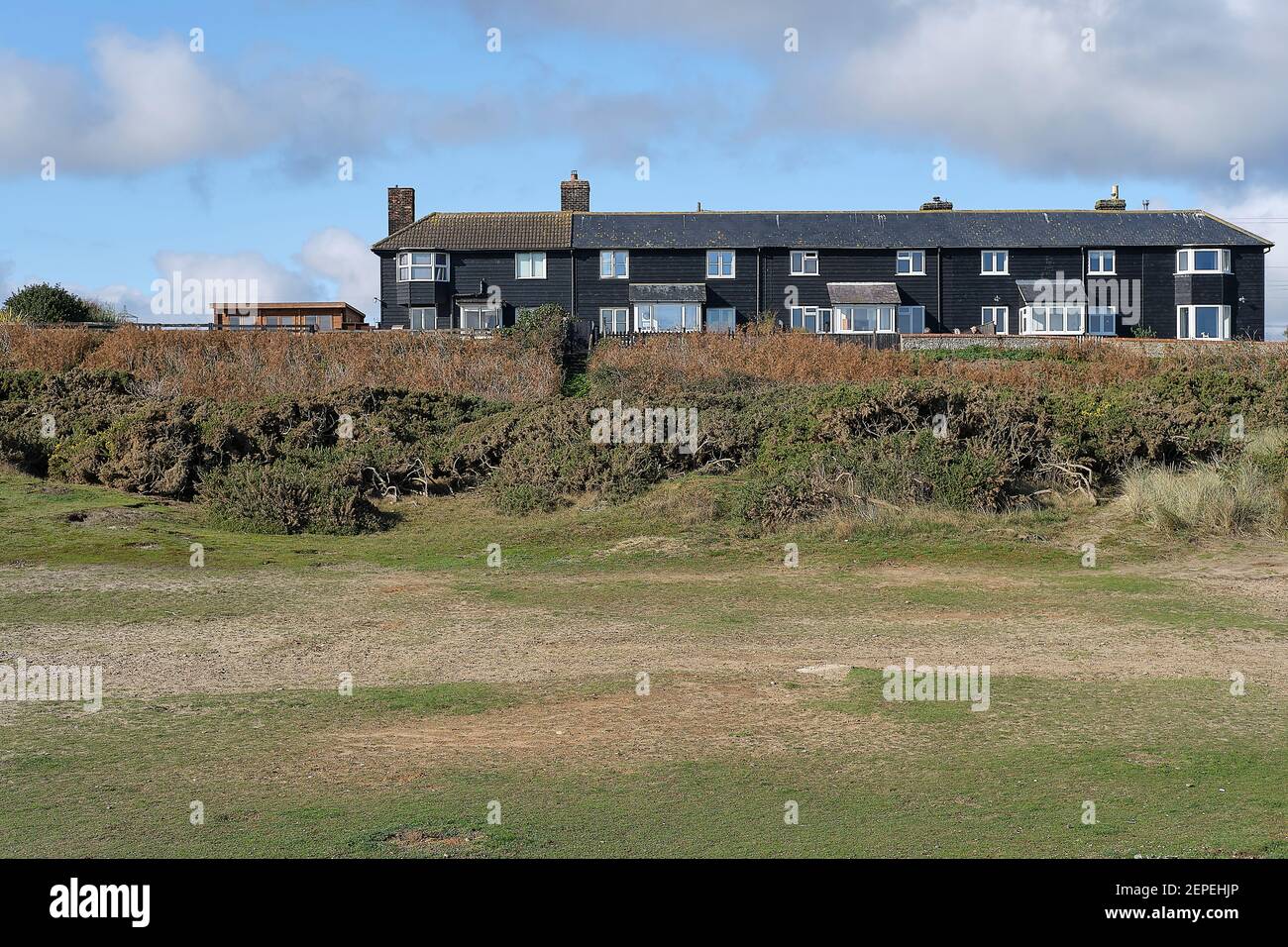 Reihe von Küstenwache Cottages, Sizewell Gap, Sizewell Suffolk. Reihe von schwarzen Cottages genannt Coastguard Cottages in Sizewell an der Suffolk Küste. Stockfoto