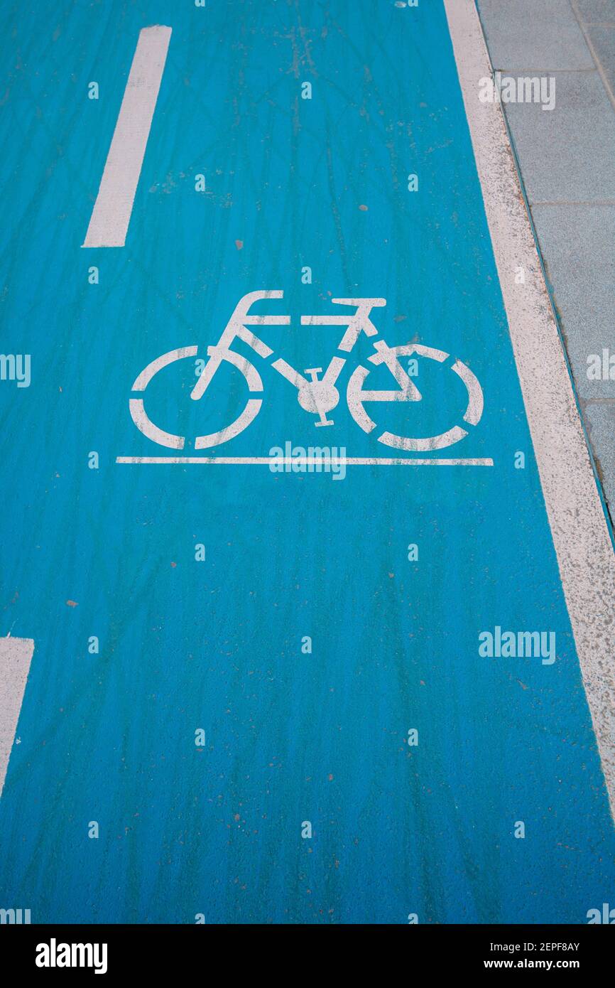 Bike Road Schild auf dem blauen Hintergrund. Gesunder Lebensstil. Fahrradweg in der Stadt. Gebrauchte Fahrradstrecke. Fahrradreifen Spuren auf der Straße. Stockfoto