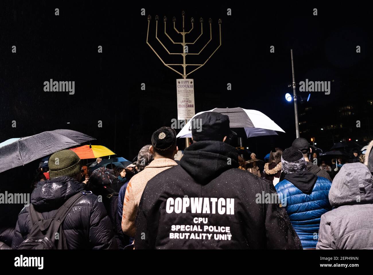 Ein Mitglied von Cop Watch schließt sich den New Yorkern solidarisch an der Beleuchtung der Menorah in der 8th Nacht von Chanukah auf dem Grand Army Plaza in Brooklyn, New York, am 29. Dezember 2019 an. (Foto von Gabriele Holtermann-Gorden/Sipa USA) Stockfoto