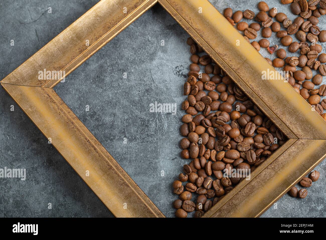 Haufen aromatischer Kaffeebohnen und leerer Rahmen auf Marmor Hintergrund Stockfoto