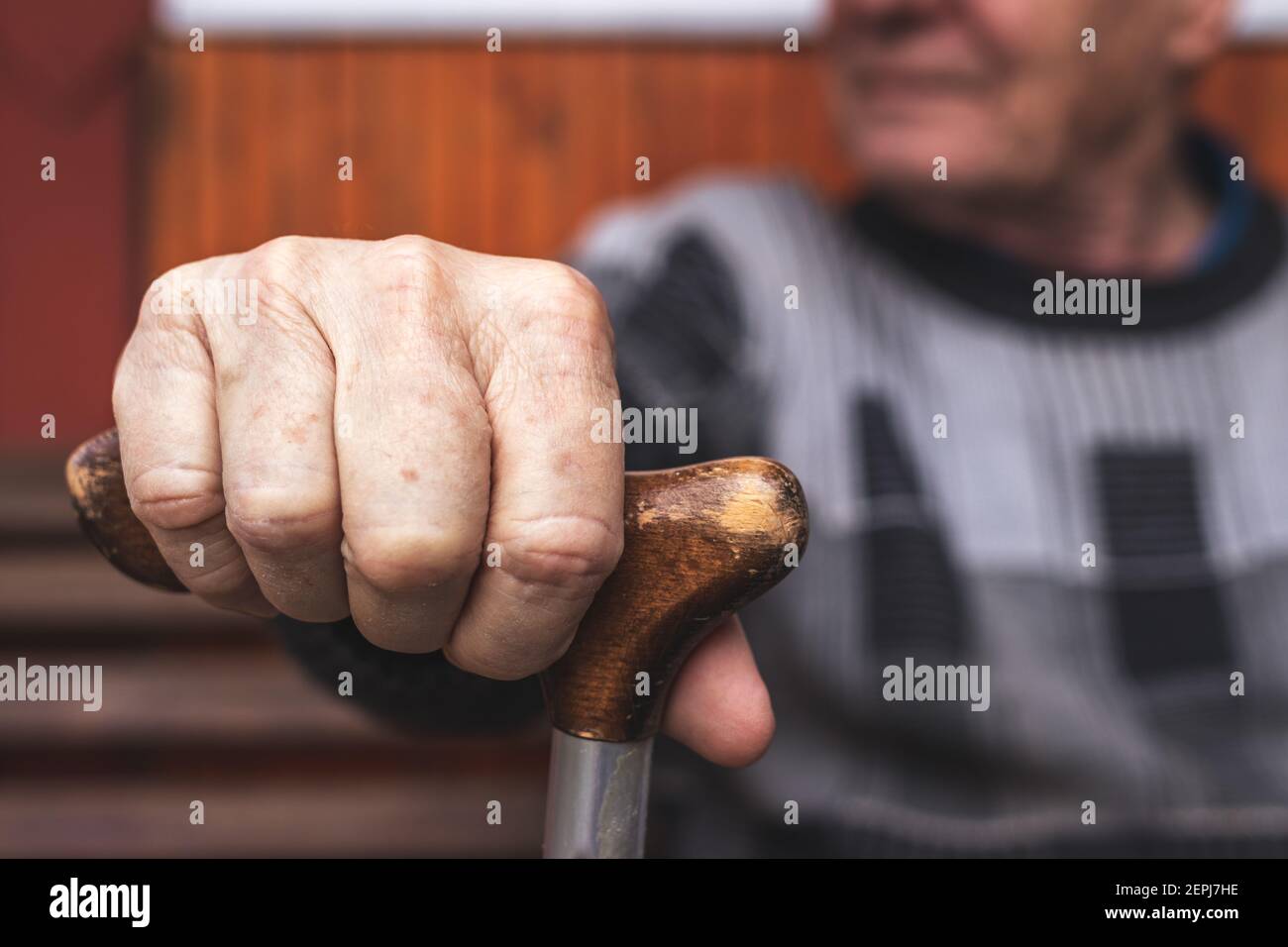 Älterer Mann, der Gehstock in der Hand hält. Alter Rentner sitzt auf der Bank und entspannt. Alterungsprozess und Behinderung Problem Stockfoto