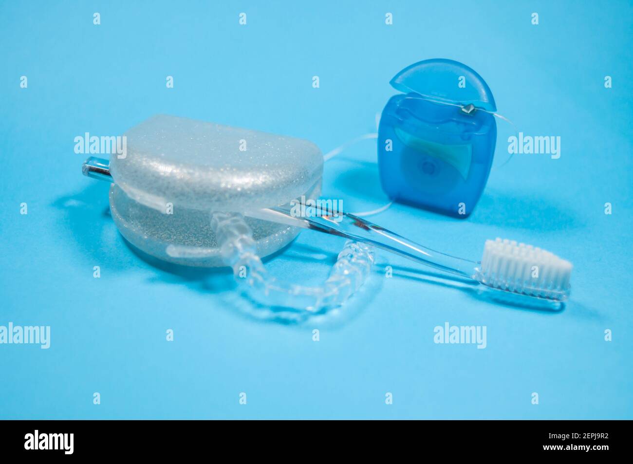 Eine Zahnschiene liegt in einer offenen Aufbewahrungsbox. Es gibt eine  Zahnbürste und eine Packung Zahnseide Stockfotografie - Alamy