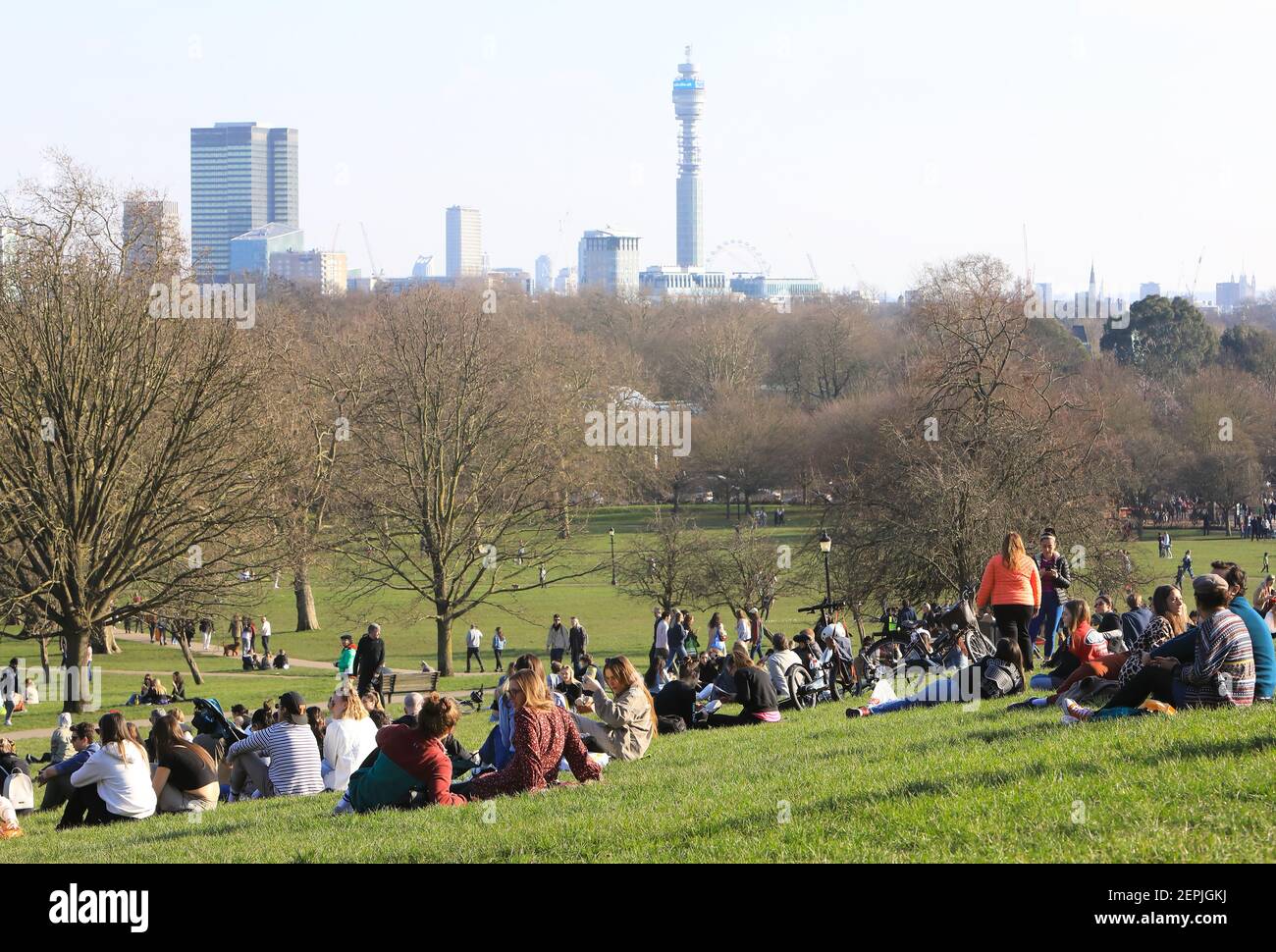 London, Großbritannien, 27th. Februar 2021. Die Leute strömten nach Primrose Hill, im Norden Londons, um ein Picknick zu machen und die ungewöhnlich warme Wintersonne zu genießen, trotz der Covid-Einschränkungen. Bei klarem Wetter hatte man eine tolle Aussicht auf die Stadt. Monica Wells/Alamy Live News Stockfoto