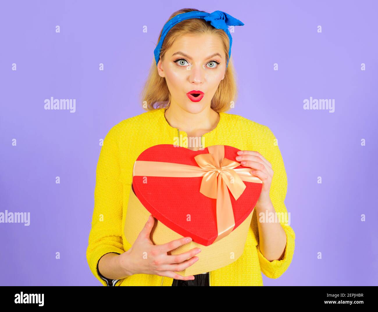 Valentinstag. Überrascht Frau mit Geschenk. Herzförmige Box. Stockfoto