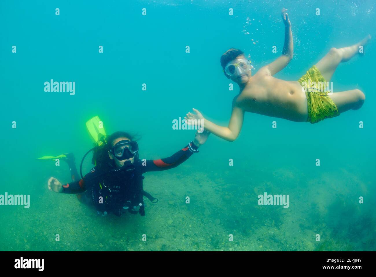 , Taucherin, die unter Wasser mit ihrer Sonne spielt, St. Kanzian am Klopeiner See, Klopein See, Österreich Stockfoto