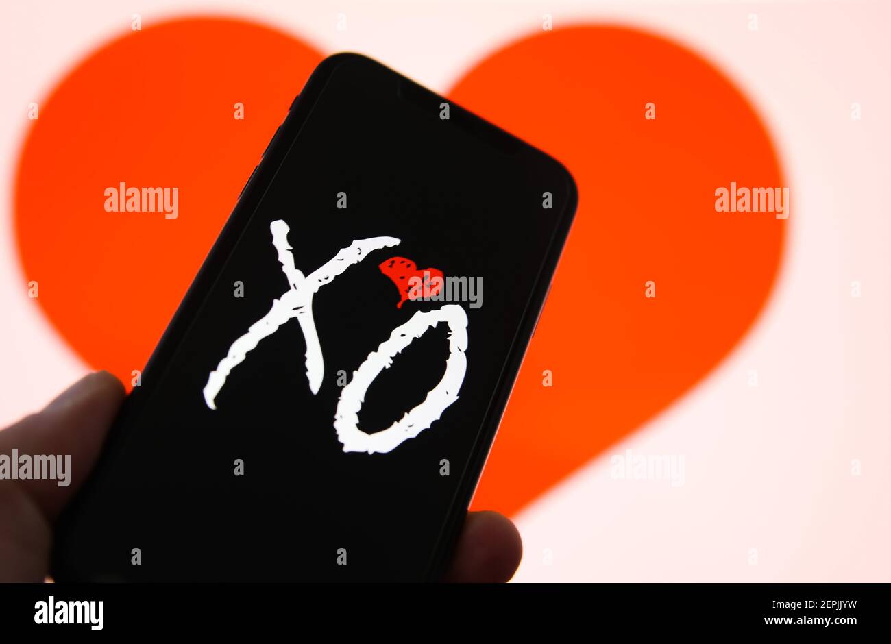 Viersen, Deutschland - Februar 9. 2021: Nahaufnahme des Handybildschirms mit Logo-Schriftzug der Online-Dating-Agentur-App XO, verschwommener Herzhintergrund Stockfoto