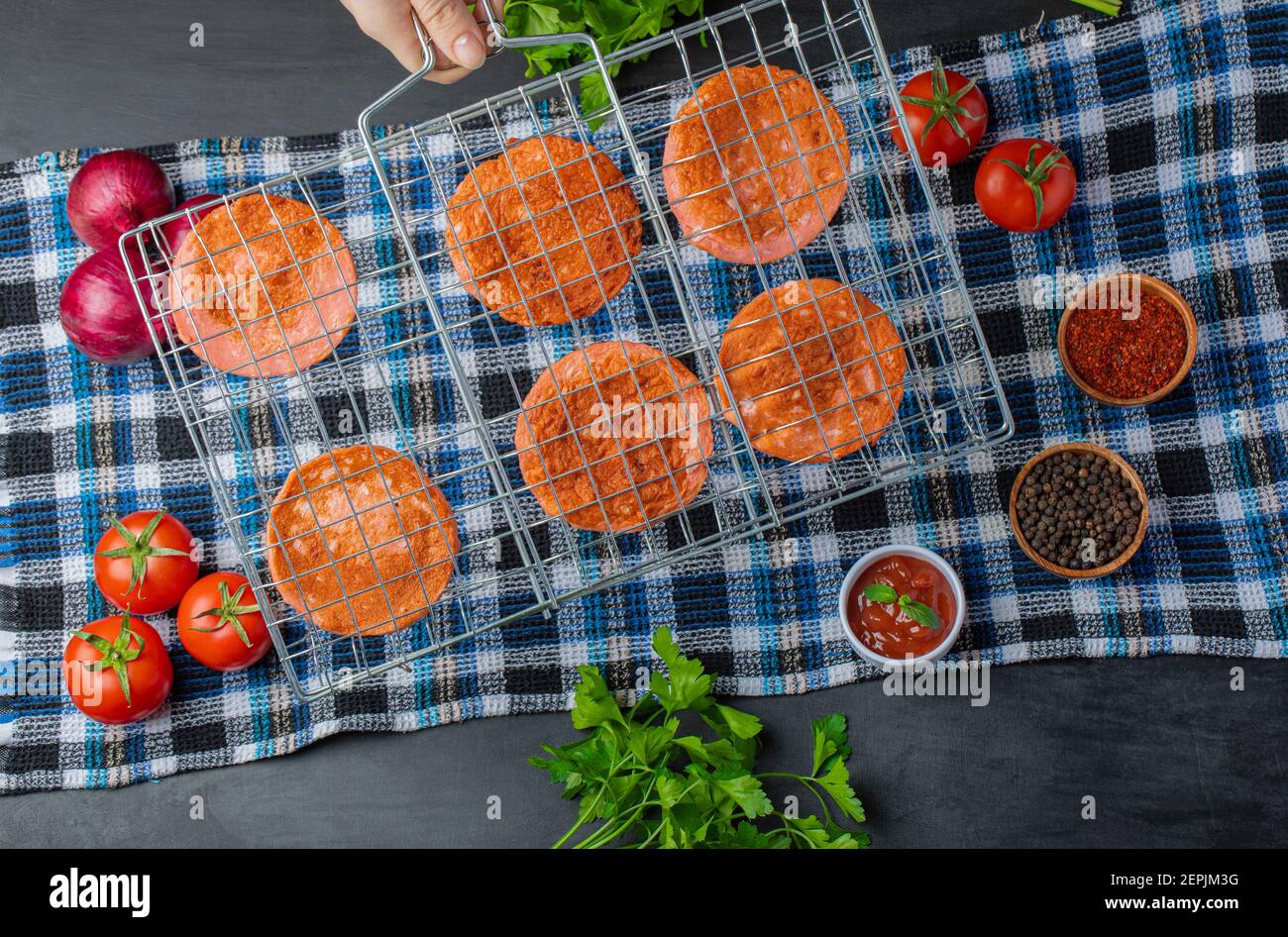 Gegrillte Salami-Scheiben auf Grillrost über frischem Gemüse Stockfoto