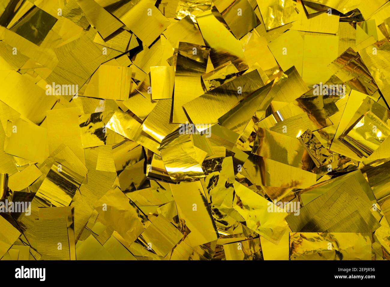 Konfetti in glänzendem Gold Farbe liegend als Hintergrund, goldene Folienpartikel Flocken Textur Struktur Stockfoto