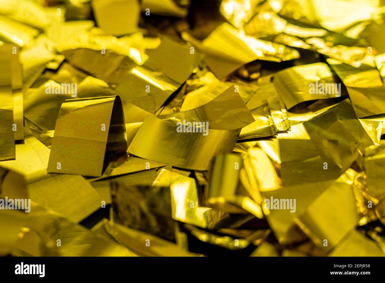 Konfetti in glänzendem Gold Farbe liegend als Hintergrund, goldene Folienpartikel Flocken Textur Struktur Stockfoto