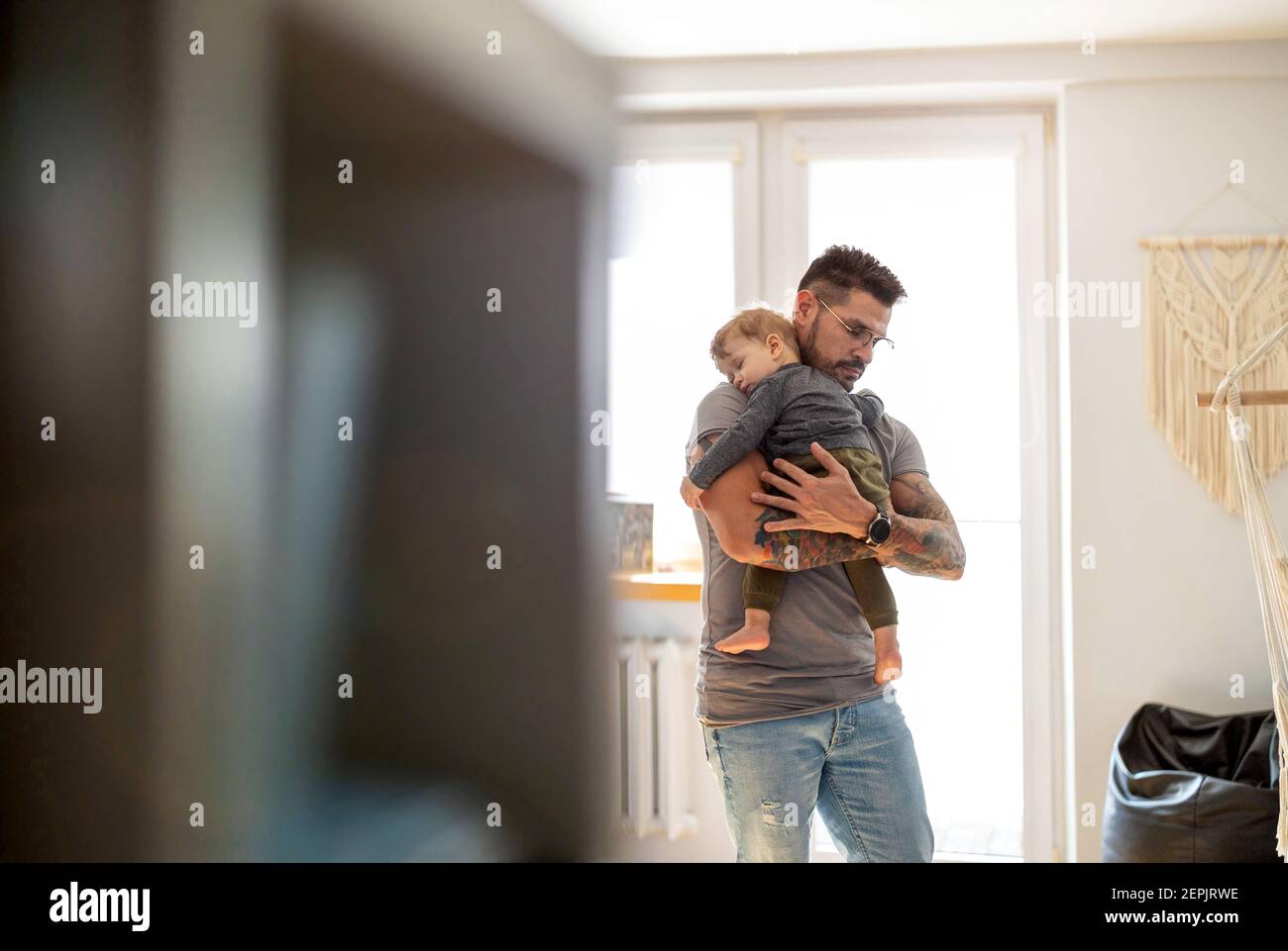 Papa legte zu schlafen Baby Junge in seinen Armen an Zu Hause Stockfoto