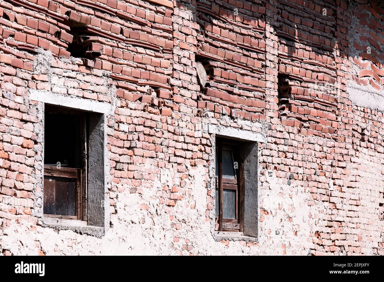Im Freien ruinierte braune Ziegelwand Fragment mit Fenstern Stockfoto