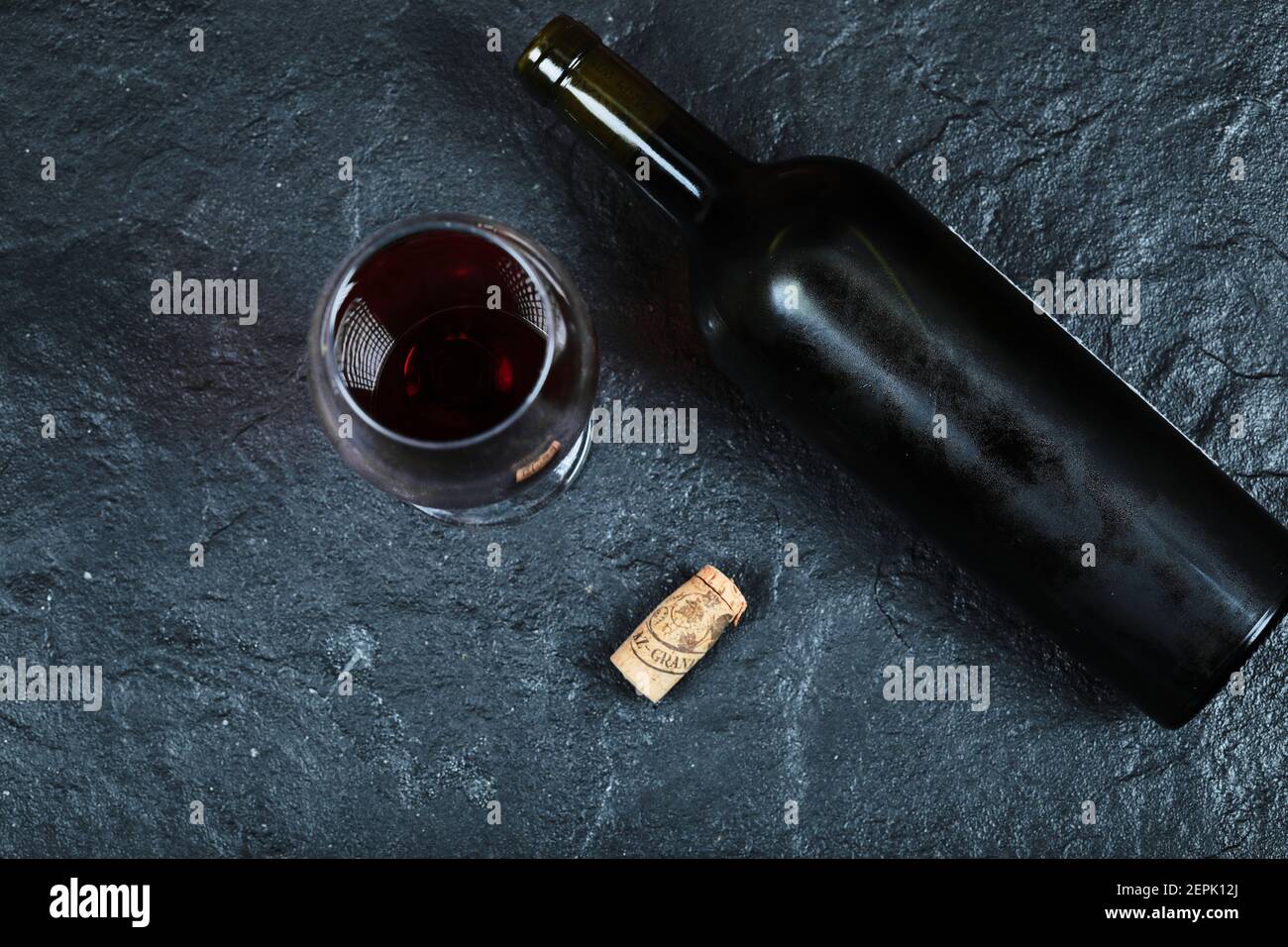 Flasche Wein mit einem Glas Wein im Dunkeln Hintergrund Stockfoto