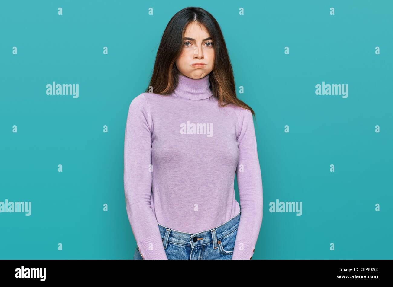 Junge schöne Teenager-Mädchen tragen Rollkragenpullover Puffing Wangen mit lustigen Gesicht. Mund mit Luft aufgeblasen, verrückte Ausdruck. Stockfoto