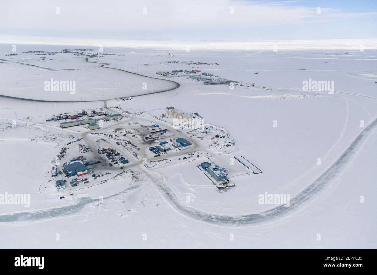 Luftaufnahme des Industriegebiets der Inuvialuit Gemeinde Tuktoyaktuk, umgeben vom gefrorenen Arktischen Ozean, Nordwest-Territorien, Kanada. Stockfoto