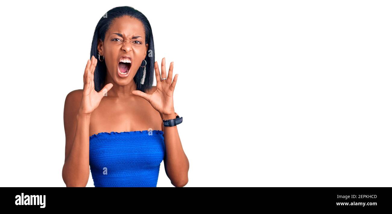 Junge afroamerikanische Frau trägt lässige Sommerkleidung schreien wütend Laut mit den Händen über dem Mund Stockfoto