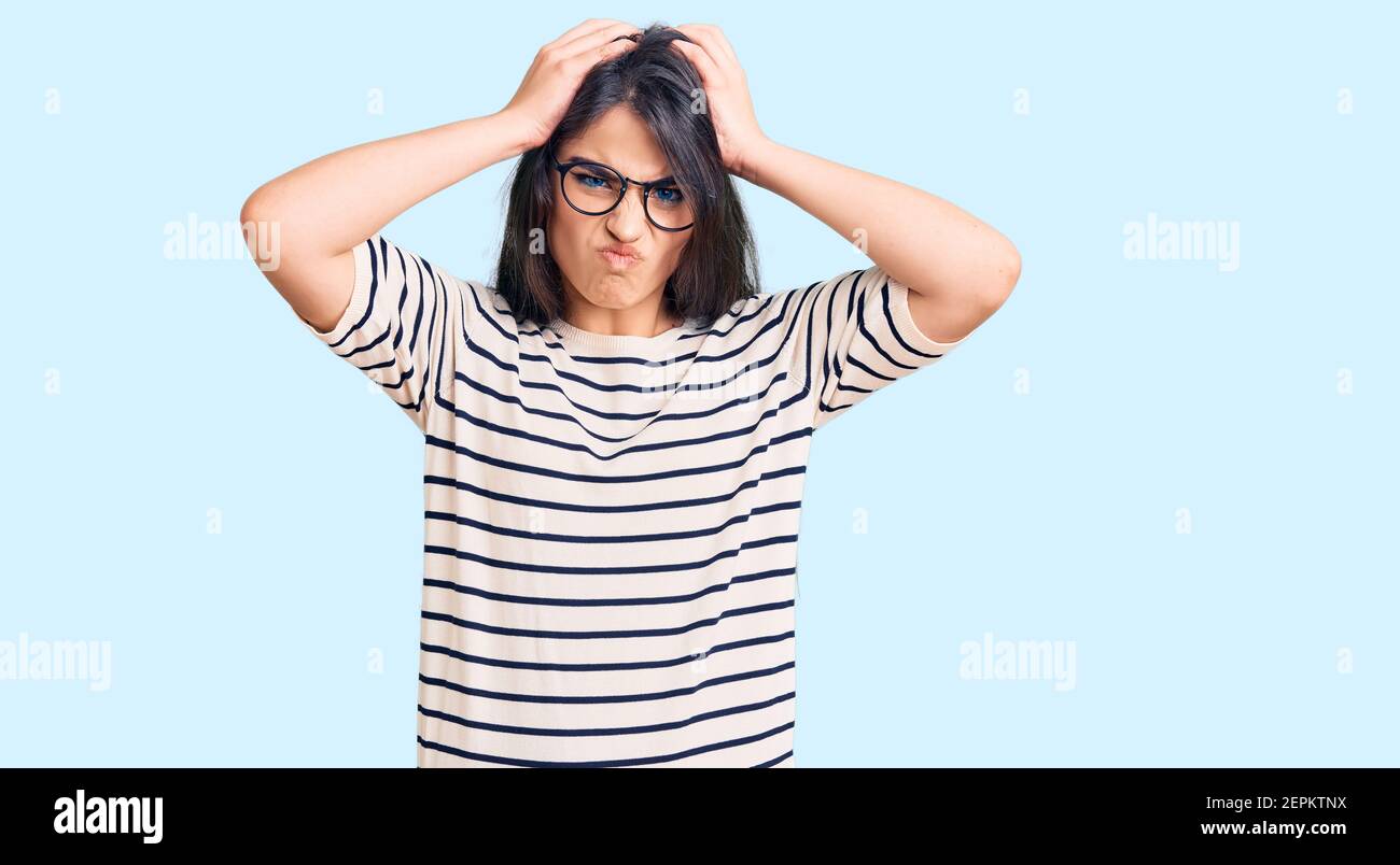 Brunette Teenager Mädchen tragen Freizeitkleidung und Brille leiden unter  Kopfschmerzen verzweifelt und gestresst, weil Schmerzen und Migräne. Hände  auf dem Kopf Stockfotografie - Alamy