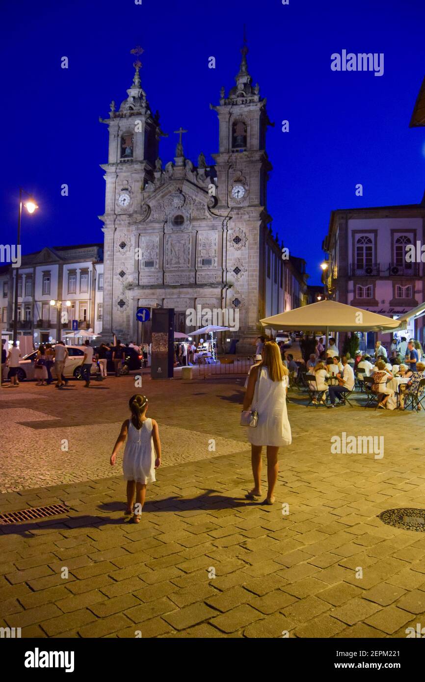 Stadt Braga in Portugal, Nachtleben der besten europäischen Stadt Ziel 2021, Santa Cruz Kirche. Mutter und Tochter gehen nachts sicher in der Stadt Stockfoto