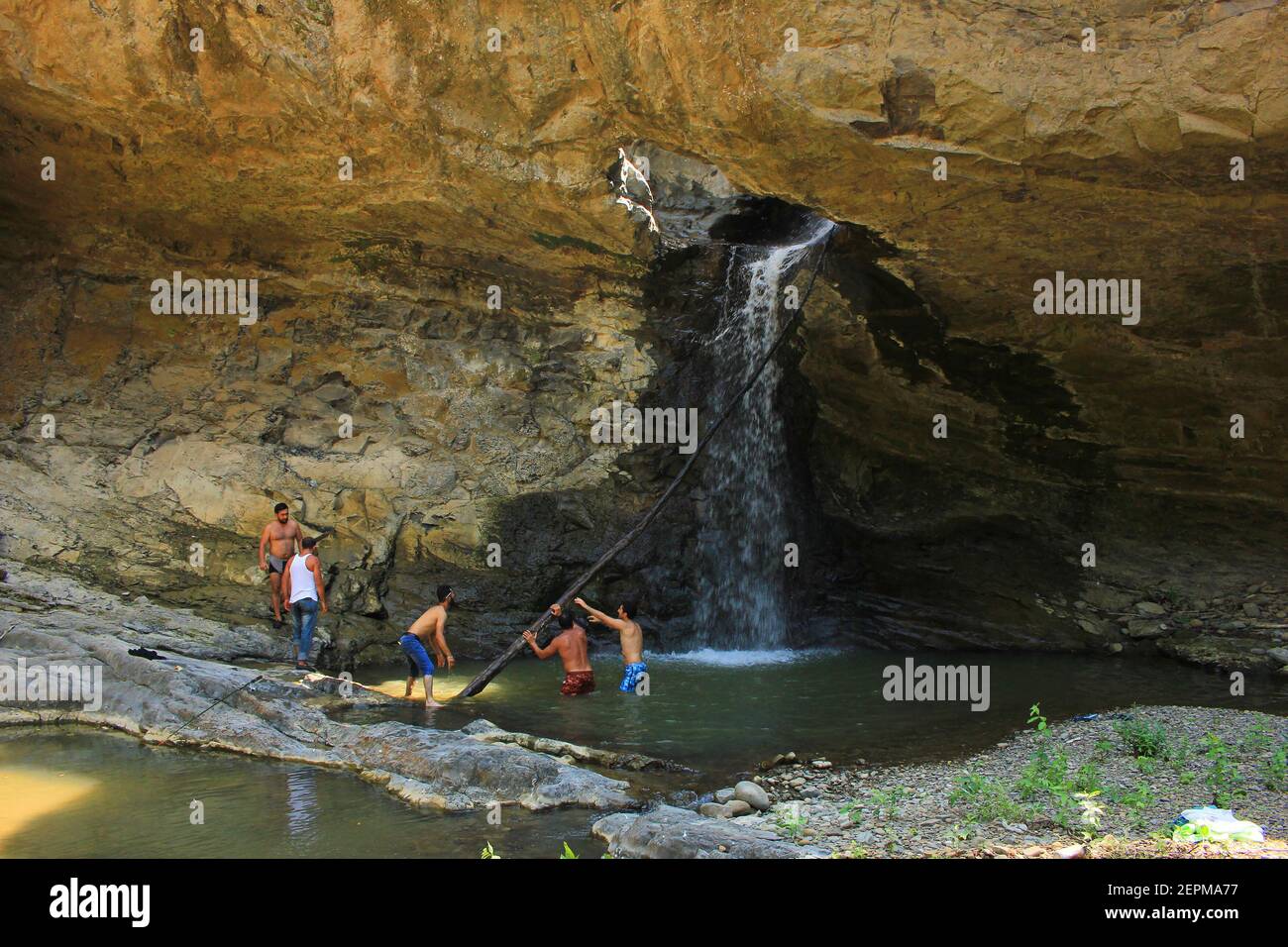 Lankaran Stadt. Aserbaidschan. 08,26.2018. Männer ziehen einen festgesteckten Baum aus einem Wasserfall. Stockfoto
