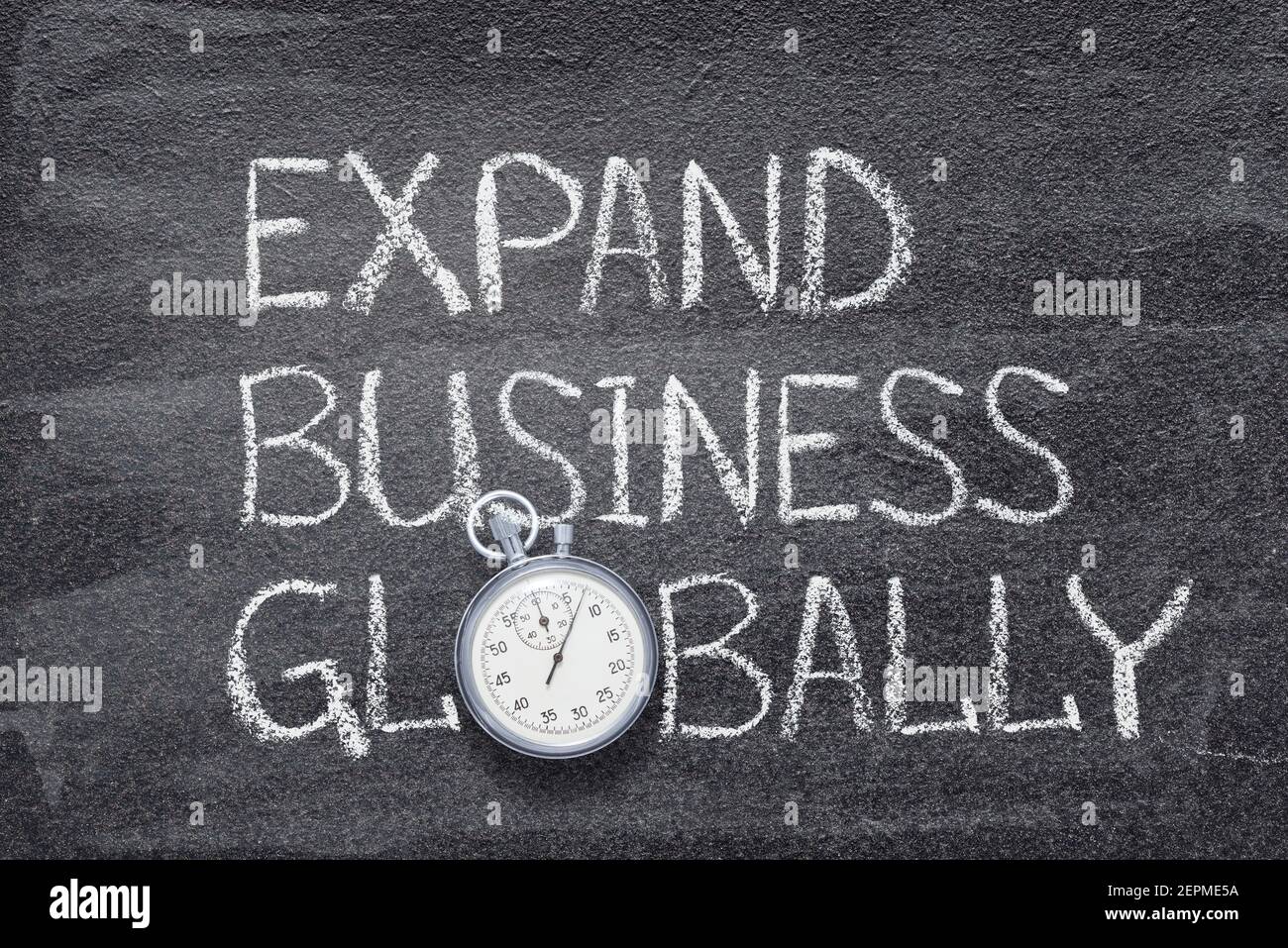 Erweitern Sie Ihre Geschäfte weltweit Ausdruck auf Tafel mit vintage präzise geschrieben Stoppuhr Stockfoto