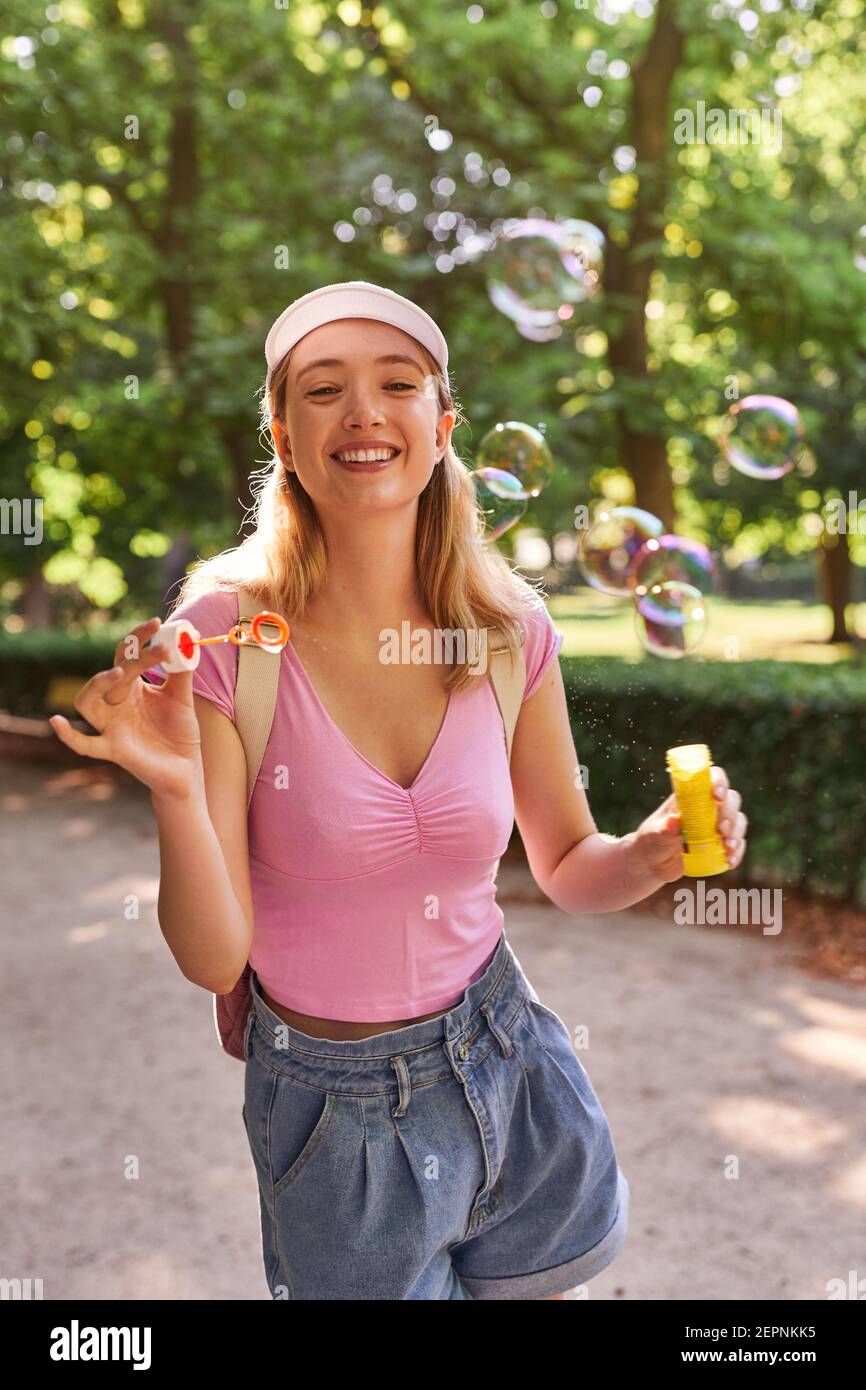 Sorglose Teenager-Frau Blasen blasen, während sonnigen Tag in verbringen Grüner Park in Madrid Stockfoto