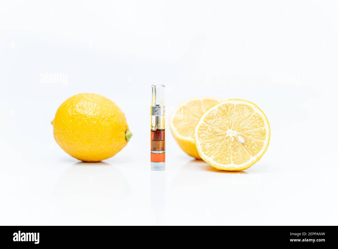 Cannabis vape Patrone und Zitronen auf weißem Hintergrund. Limonen-Terpene-Konzept. Stockfoto