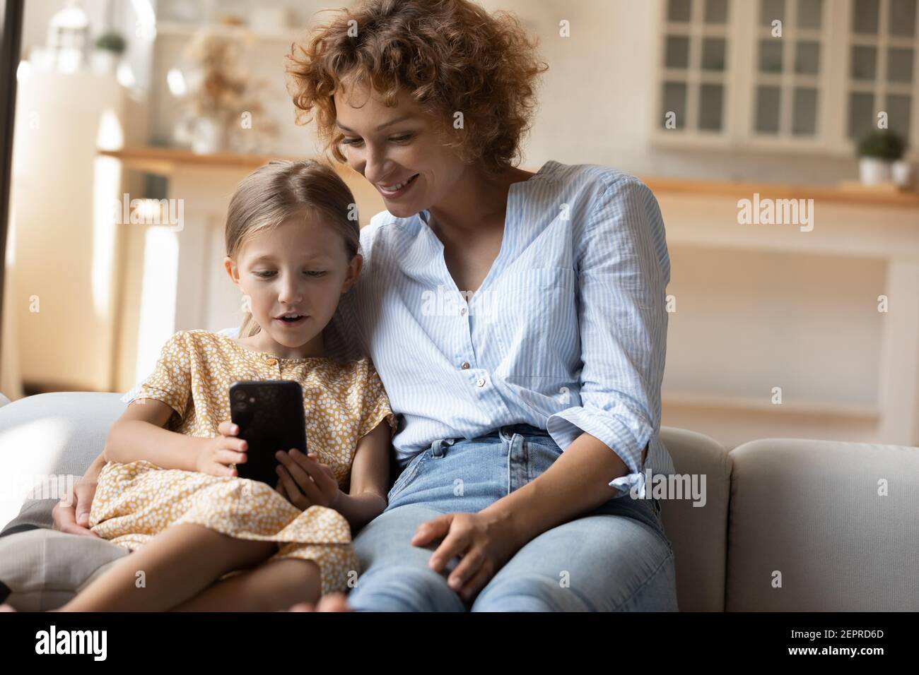 Adoptierte Kind verbringen gerne Zeit mit Pflegemutter mit Telefon Stockfoto