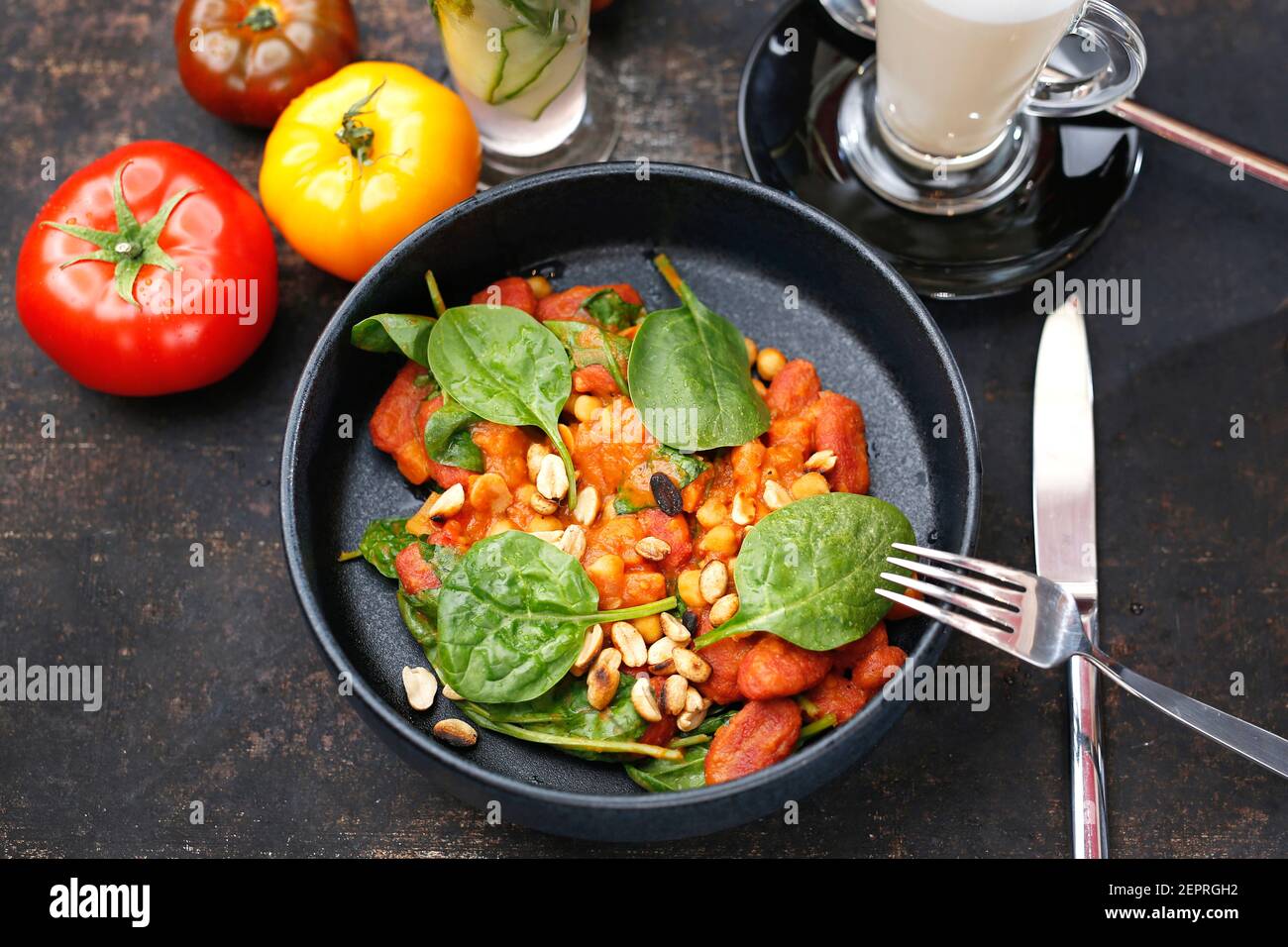Tomaten gebacken mit Spinat und Erdnüssen. Essen auf einem Teller serviert, Essen Styling, Serviervorschläge, kulinarische Fotografie. Stockfoto
