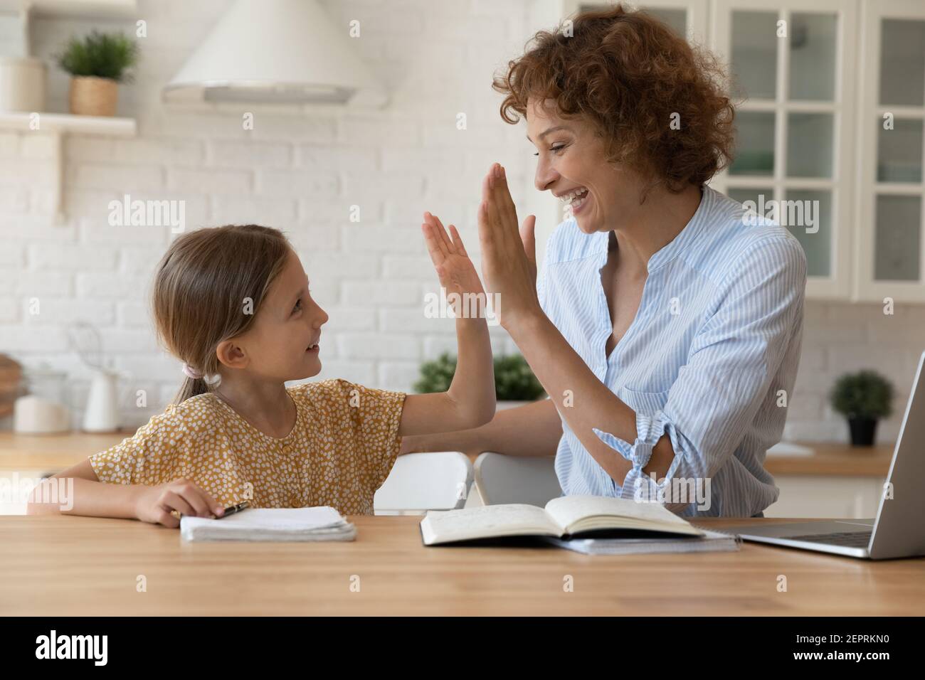 Aufgeregte Mutter geben hohe fünf kleine Tochter Lob Kind Stockfoto