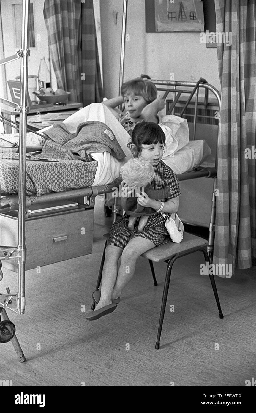 Childrens Ward Cardiff Hospital. Mädchen sitzt neben Jungen im Bett Stockfoto