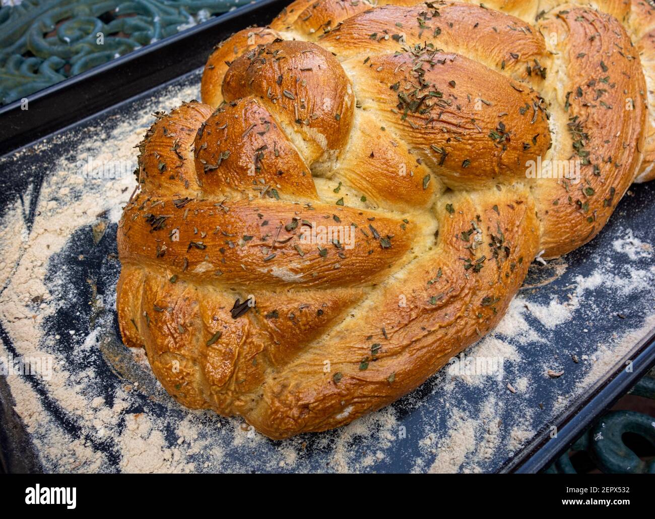 Geflochtenes Brot auf bemehltem Backblech Stockfoto