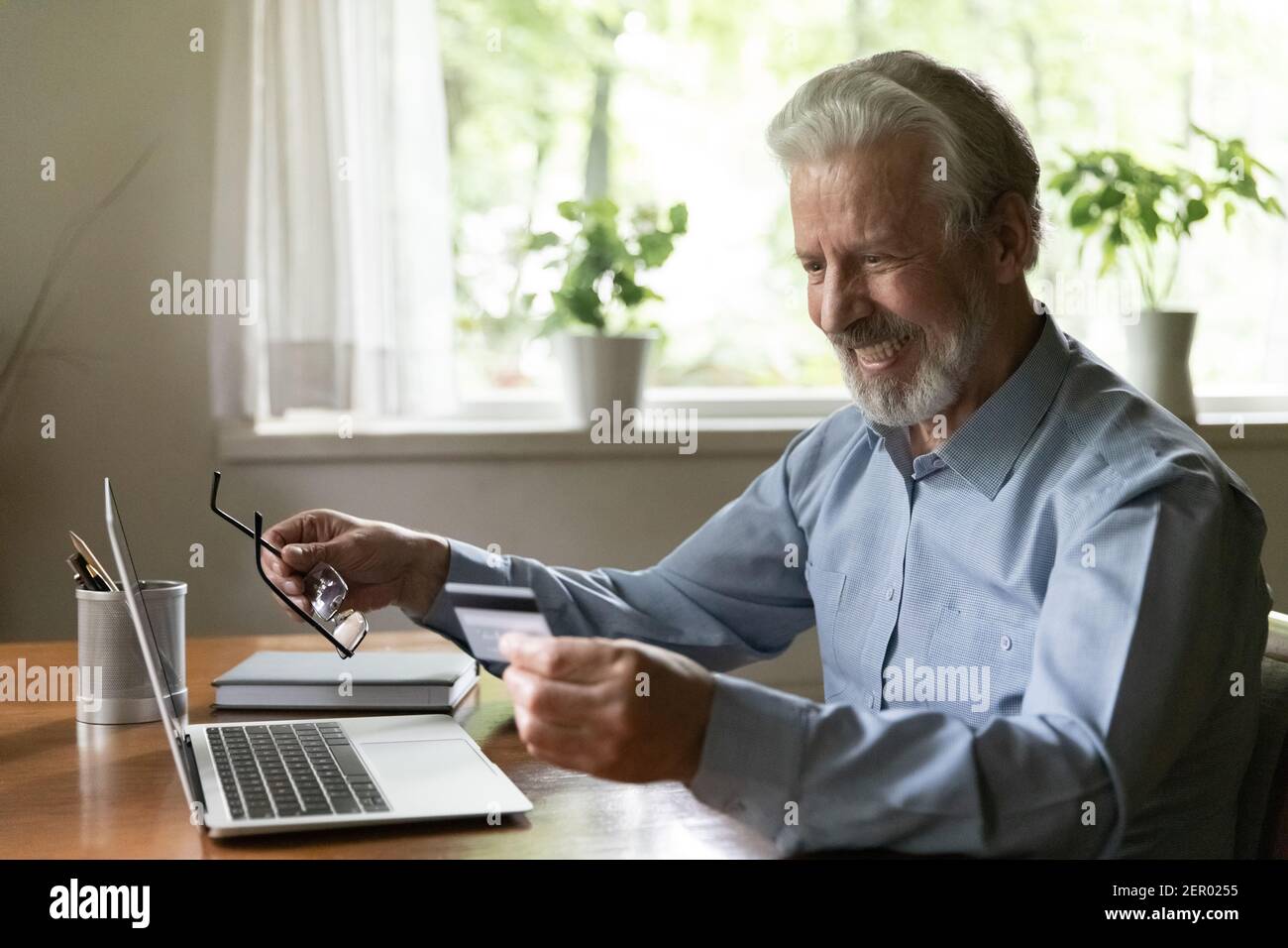 Glückliche ältere Kunden, die online von zu Hause aus einkaufen Stockfoto