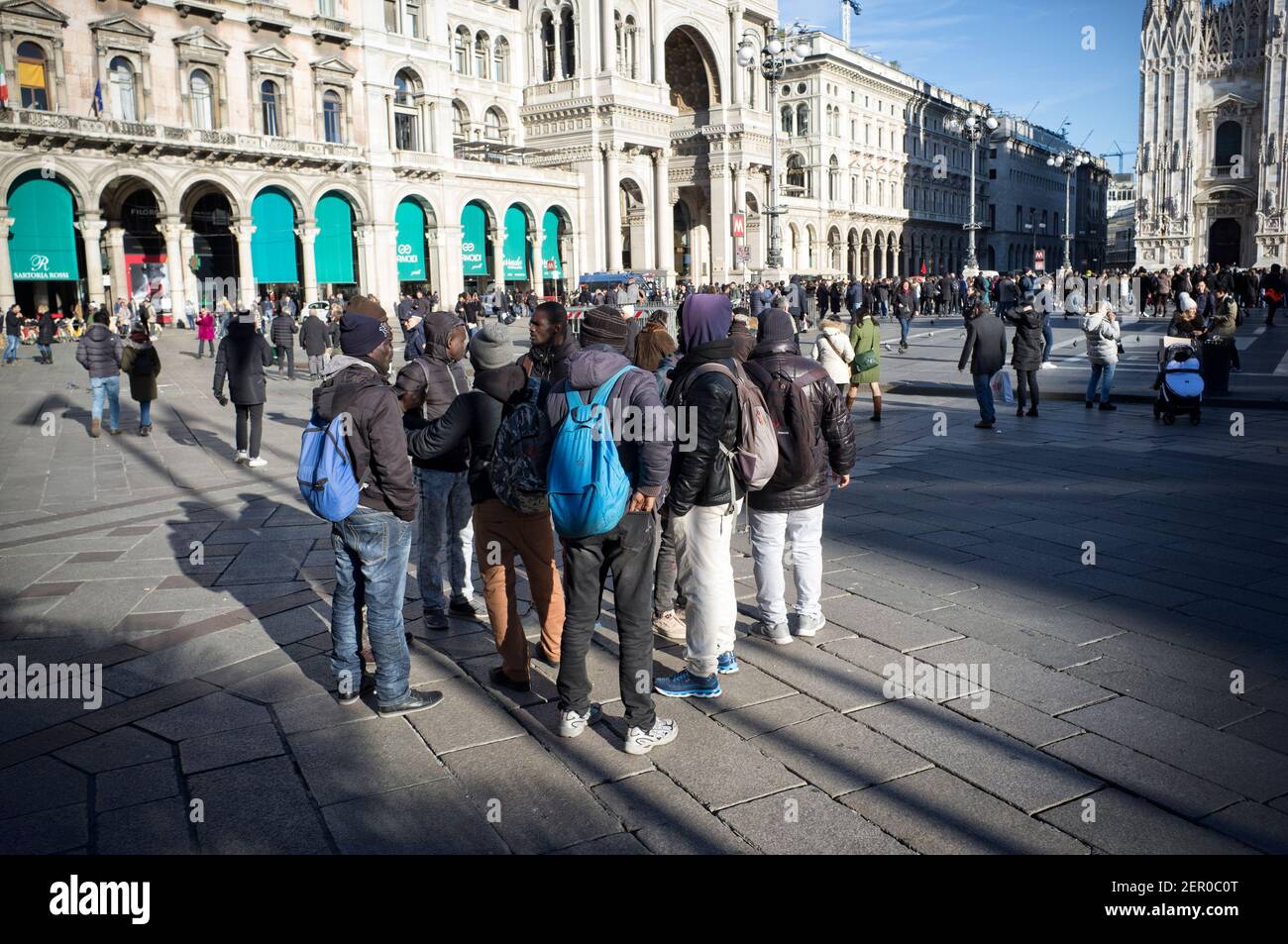 Mailand, Italien - 11. Januar 2019: Afrikanische schwarze Männer, Männer, Immigranten, die auf dem Mailänder Duomo Platz stehen, mit Touristen Stockfoto