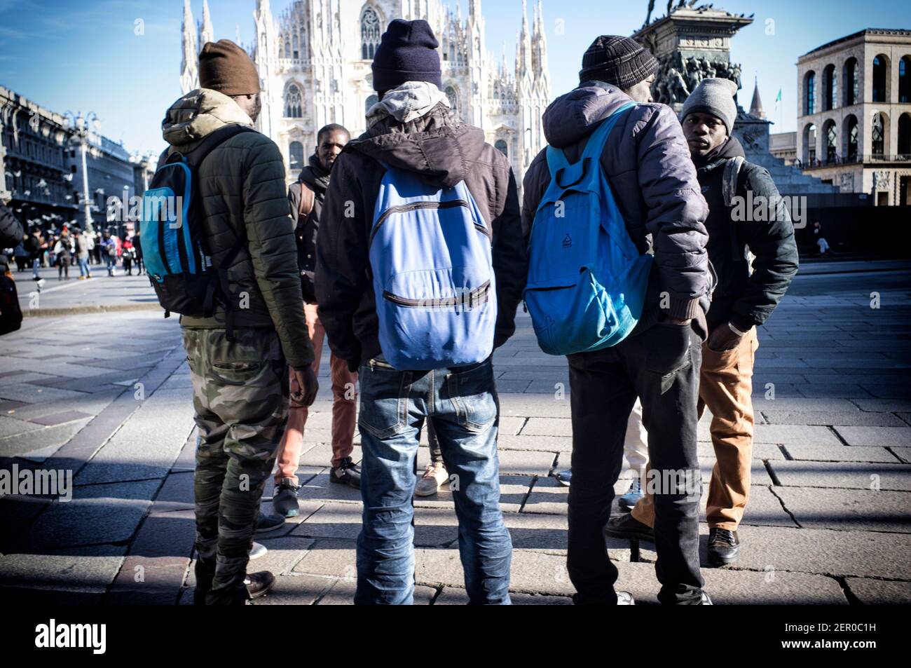 Mailand, Italien - 11. Januar 2019: Afrikanische schwarze Männer, Männer, Immigranten, die auf dem Mailänder Duomo Platz stehen, mit Touristen Stockfoto