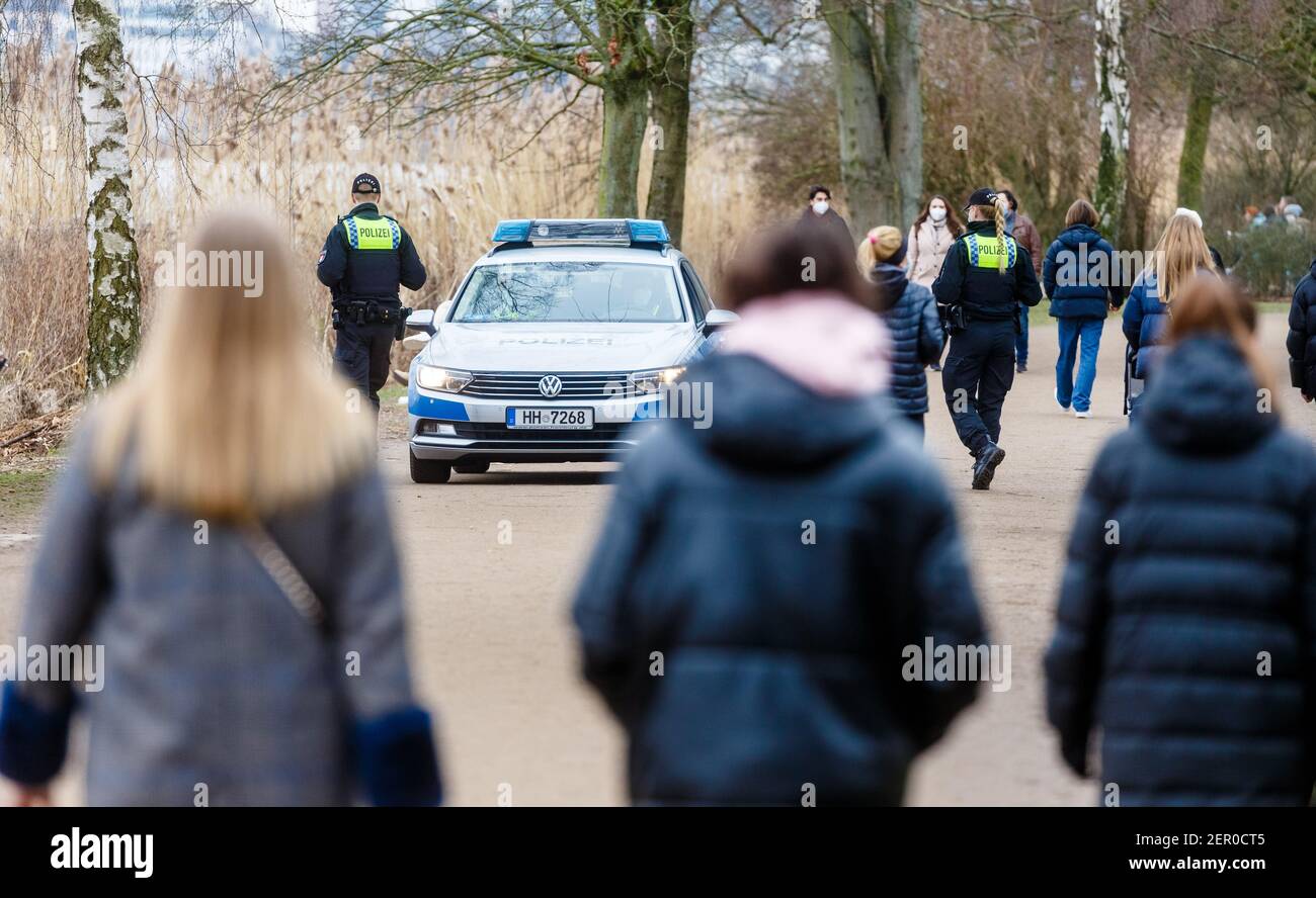 Hamburg, Deutschland. Februar 2021, 28th. Polizeibeamte patrouillieren zu Fuß und in Fahrzeugen rund um die Hamburger Außenalster, um die seit Samstag in Kraft getretene erweiterte Maskenpflicht durch direkte Ansprache zu überwachen und durchzusetzen. Quelle: Markus Scholz/dpa/Alamy Live News Stockfoto