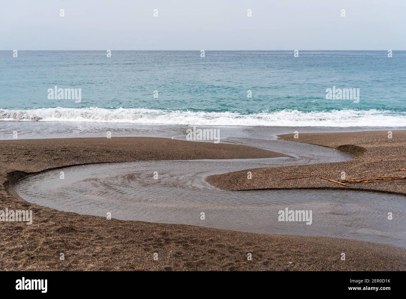 Kleiner Mäander eines Baches, wenn er das Meer erreicht. Stockfoto