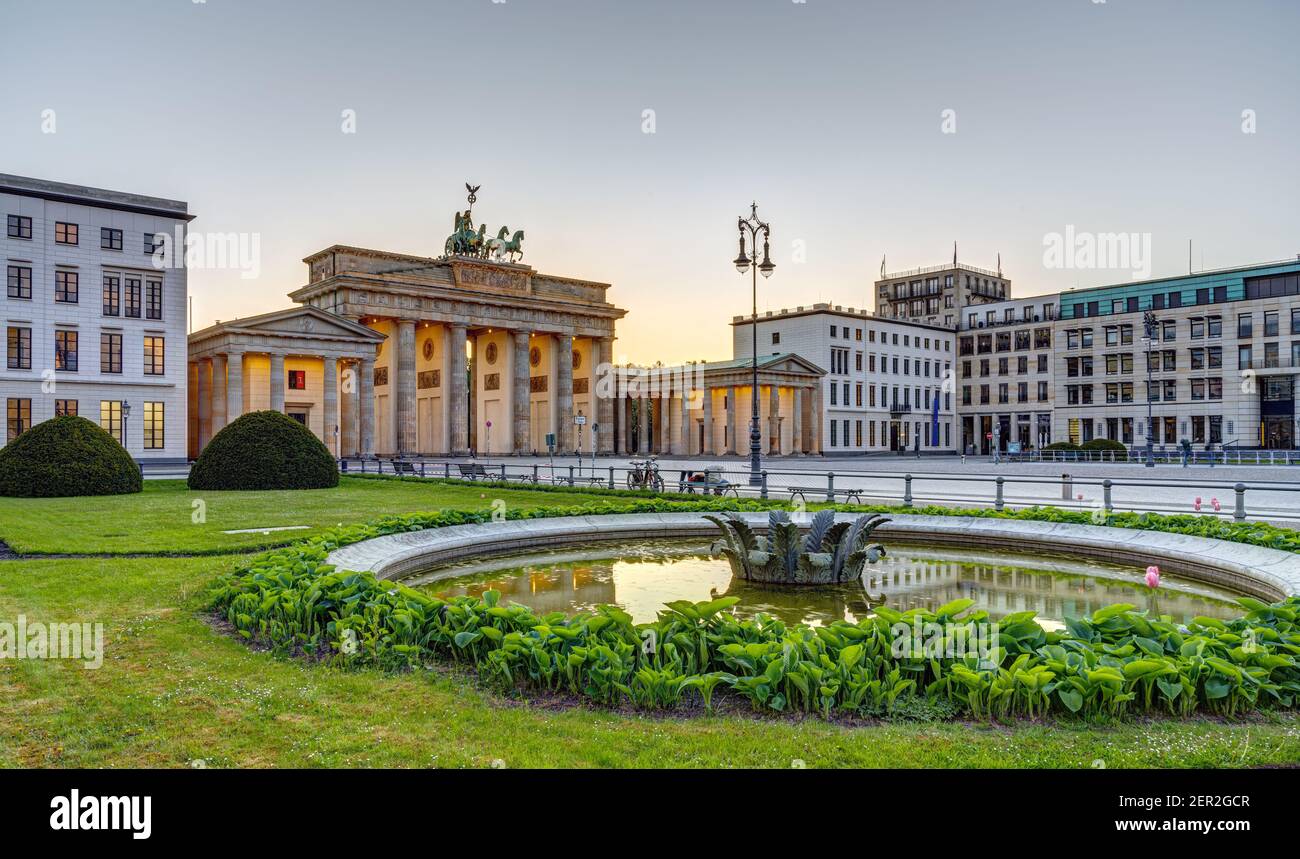 Das berühmte Brandenburger Tor in Berlin nach Sonnenuntergang mit einem Brunnen Stockfoto