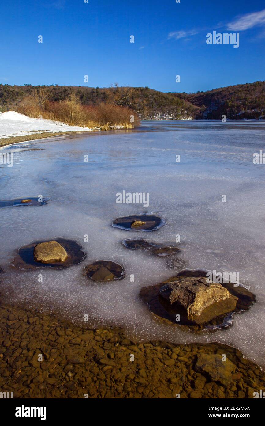 Eine späte Wintersonne erzeugt Sonnenerwärmung verursacht Schnee und Eis schmelzen entlang dem Ufer des Beltzville Lake in Carbon County, Pennsylvania Stockfoto